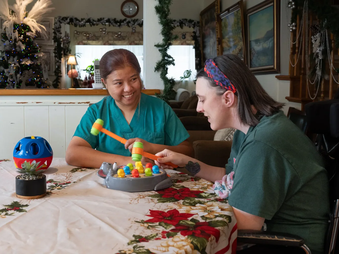 Caregiver and resident enjoying a therapeutic activity game together at home during the holidays